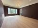 Cozy bedroom with hardwood floors, a large window providing ample natural light, and neutral paint at 7208 Tanbark Way, Raleigh, NC 27615