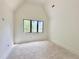 Bright bedroom with vaulted ceiling and a window with black trim at 7208 Tanbark Way, Raleigh, NC 27615