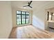 Bedroom with a ceiling fan, hardwood floors, and a large window for natural light at 7208 Tanbark Way, Raleigh, NC 27615