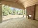 A covered patio with a fireplace and an outdoor view of wooded property at 7208 Tanbark Way, Raleigh, NC 27615