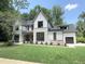 Elegant two-story home with a green lawn, stone accents, an attached garage, and a well-maintained landscape at 7208 Tanbark Way, Raleigh, NC 27615
