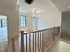 Bright hallway with hardwood floors, modern railing, large windows and chandelier at 7208 Tanbark Way, Raleigh, NC 27615