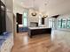 Spacious kitchen featuring a large island, hardwood floors, high ceilings, pendant lights, and many windows at 7208 Tanbark Way, Raleigh, NC 27615
