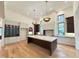 Spacious kitchen with hardwood floors, custom cabinets, an island, and modern lighting at 7208 Tanbark Way, Raleigh, NC 27615