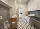 Bright laundry room features custom cabinets, black countertops and black and white patterned backsplash and floor tile at 7208 Tanbark Way, Raleigh, NC 27615
