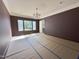 Living room with maroon walls, crown molding, chandelier, and large windows at 7208 Tanbark Way, Raleigh, NC 27615