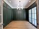Stylish dining room featuring a modern chandelier, dark green walls, and access to an outdoor space at 7208 Tanbark Way, Raleigh, NC 27615