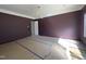 Living room with maroon walls, white crown molding, view of doorway, and large window at 7208 Tanbark Way, Raleigh, NC 27615