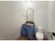 Powder room features a wood floor, brushed gold hardware and a granite countertop at 7208 Tanbark Way, Raleigh, NC 27615