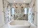 Elegant bathroom featuring a soaking tub and shower area with marble walls and dual shower heads at 7208 Tanbark Way, Raleigh, NC 27615