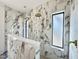 Elegant marble tiled shower featuring double shower heads and window in new construction home at 7208 Tanbark Way, Raleigh, NC 27615