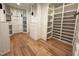 Spacious walk-in closet with custom shelving and hardwood floors at 7208 Tanbark Way, Raleigh, NC 27615