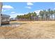 This home features a large backyard with a covered deck and a forest in the background at 100 Bold Dr, Youngsville, NC 27596