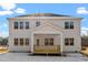This home's backyard features a covered deck, a large yard, and mature trees in the distance at 100 Bold Dr, Youngsville, NC 27596