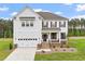 Charming two-story home featuring white siding, brown shutters, landscaped yard, and a welcoming front porch at 100 Bold Dr, Youngsville, NC 27596