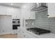 Close-up of a modern kitchen showcasing stainless steel appliances, and subway tile backsplash at 100 Bold Dr, Youngsville, NC 27596
