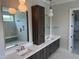 Modern bathroom with dual sinks, walk-in shower, and wood cabinets at 126 Harvest Ln, Pittsboro, NC 27312