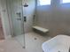 Modern bathroom featuring a glass-enclosed shower, soaking tub, and neutral tile at 126 Harvest Ln, Pittsboro, NC 27312