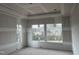 Bright bedroom showcasing large windows offering scenic neighborhood views; under construction at 126 Harvest Ln, Pittsboro, NC 27312