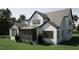 Back of charming two-story white home featuring gray roof, modern windows, and a screened porch at 126 Harvest Ln, Pittsboro, NC 27312