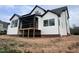 Rear view of new home featuring a walk out wooden porch with black metal railing at 126 Harvest Ln, Pittsboro, NC 27312
