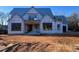 Modern farmhouse exterior featuring vertical siding, dark trim, and an unfinished yard at 126 Harvest Ln, Pittsboro, NC 27312