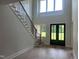 Grand foyer with soaring ceilings, hardwood floors, a modern staircase, and a stylish front door at 126 Harvest Ln, Pittsboro, NC 27312