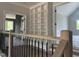Bright hallway featuring an oak railing, black balusters, and a built-in white bookcase at 126 Harvest Ln, Pittsboro, NC 27312