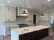 Modern kitchen features an island with dark wood cabinets, white countertops and stainless steel appliances at 126 Harvest Ln, Pittsboro, NC 27312
