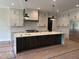 Modern kitchen features an island with dark wood cabinets, white countertops and stainless steel appliances at 126 Harvest Ln, Pittsboro, NC 27312
