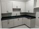 Well-appointed laundry room features white cabinets, modern fixtures, and dark countertops at 126 Harvest Ln, Pittsboro, NC 27312
