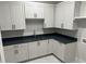 Laundry room with shaker style cabinets, dark countertops, and stainless steel sink at 126 Harvest Ln, Pittsboro, NC 27312