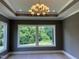 Bright living room featuring a modern chandelier and large windows offering serene outdoor views at 126 Harvest Ln, Pittsboro, NC 27312