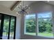 Bright living room featuring multiple windows, a statement light fixture, and access to outdoor deck at 126 Harvest Ln, Pittsboro, NC 27312