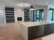 Open-concept living space with built-in shelving, fireplace, and a spacious kitchen island at 126 Harvest Ln, Pittsboro, NC 27312