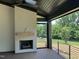 Covered porch features a painted brick fireplace and a view of the private backyard with pool at 126 Harvest Ln, Pittsboro, NC 27312
