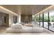 Modern living room featuring a fireplace, contemporary furnishings, wood ceiling, and expansive windows with outdoor views at 5909 Tower Grove Dr, Raleigh, NC 27614