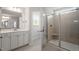 Well-lit bathroom with dual vanities, tiled shower, and a glass door at 90 Bold Dr, Youngsville, NC 27596