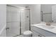 Bathroom with glass shower doors, white cabinets, quartz countertops, and modern fixtures at 90 Bold Dr, Youngsville, NC 27596