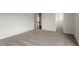 A bright bedroom with neutral walls, soft gray carpet, and doorways to other rooms at 90 Bold Dr, Youngsville, NC 27596