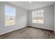Bright bedroom features wood-look flooring, neutral walls, and a view of the outdoors through two windows at 90 Bold Dr, Youngsville, NC 27596