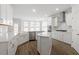 Bright kitchen with stainless appliances, white cabinets, backsplash, quartz countertops, an island, and hardwood flooring at 90 Bold Dr, Youngsville, NC 27596