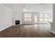Spacious living room features hardwood flooring, a corner fireplace, a ceiling fan, and large windows with a backyard view at 90 Bold Dr, Youngsville, NC 27596