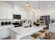 Modern kitchen features white cabinets, a quartz countertop island with seating, and stainless steel appliances at 191 Anise Ln, Garner, NC 27529