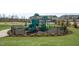 Fenced in playground with blue and green slides, and climbing areas, surrounded by a well manicured lawn at 191 Anise Ln, Garner, NC 27529