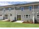 Backyard view of townhome with patio, lawn, and gray siding at 195 Anise Ln, Garner, NC 27529