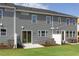 Backyard view of townhome with patio, lawn, and gray siding at 195 Anise Ln, Garner, NC 27529