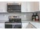 Close up of kitchen featuring stainless steel appliances, white cabinets, and granite countertops at 195 Anise Ln, Garner, NC 27529