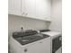 Well-lit laundry room with modern, front-loading washer and dryer and overhead cabinets at 195 Anise Ln, Garner, NC 27529