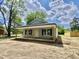 Single-story home featuring gray siding, black shutters, and a covered front porch provides a quaint curb appeal at 233 Jenkins St, Erwin, NC 28334